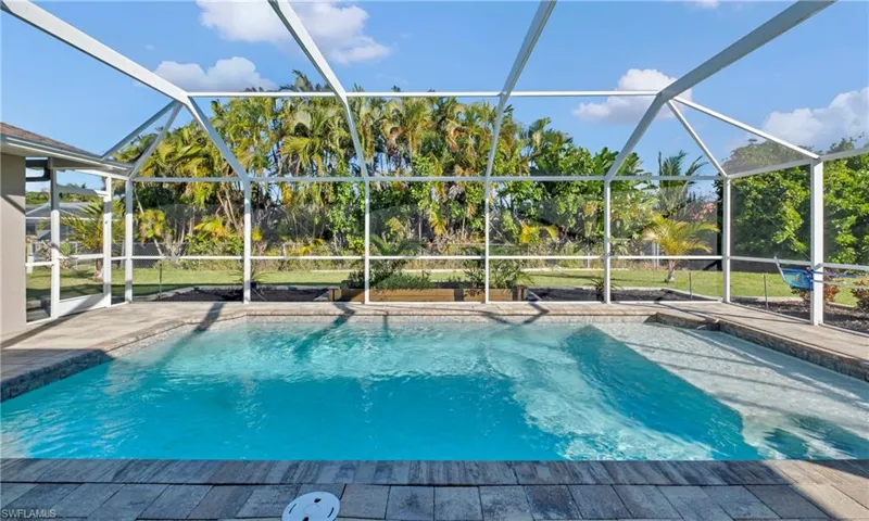 Outdoor pool with a sunroom, glass enclosure, and a patio