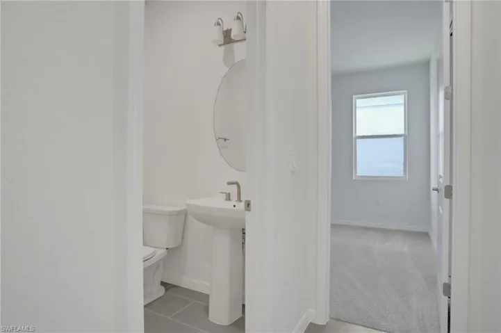 Half bath with toilet and light tile patterned floors