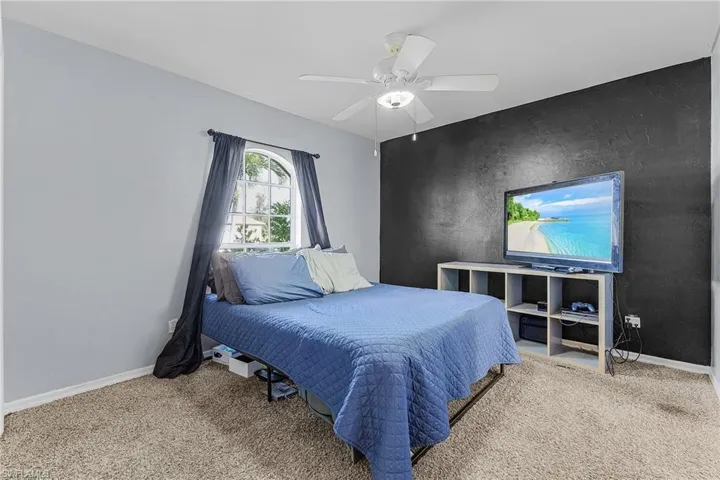 Bedroom with carpet flooring, ceiling fan, and baseboards