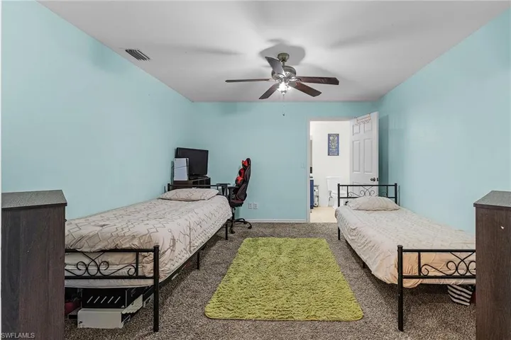 Carpeted bedroom featuring a ceiling fan
