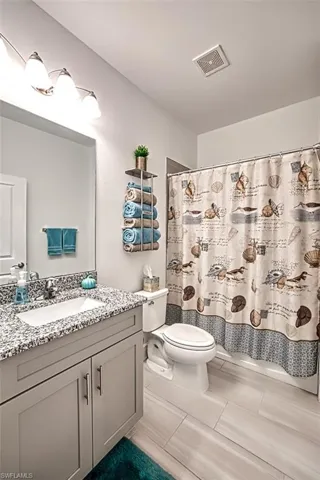 Bathroom with curtained shower and vanity
