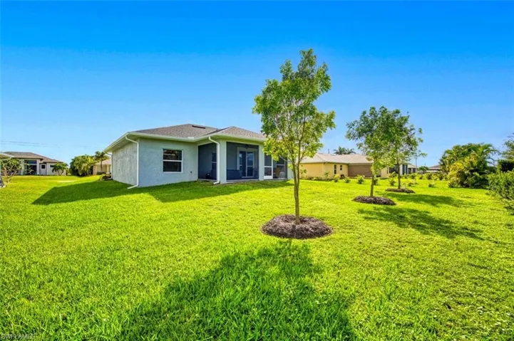 Back of property featuring a yard, stucco siding, and a sunroom