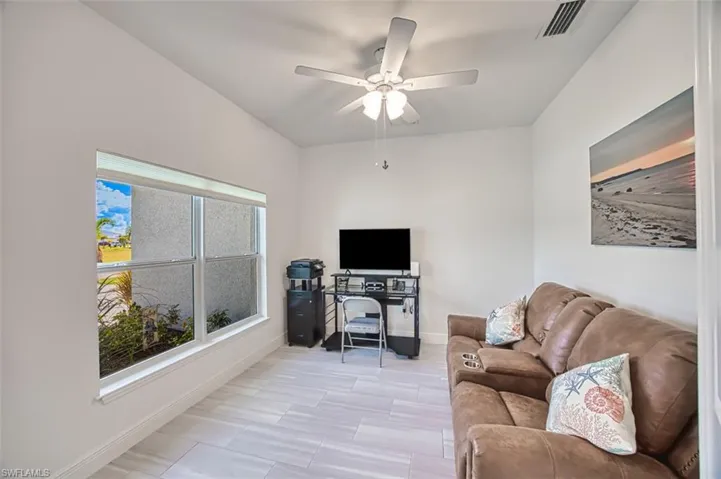 Home office with a ceiling fan and baseboards
