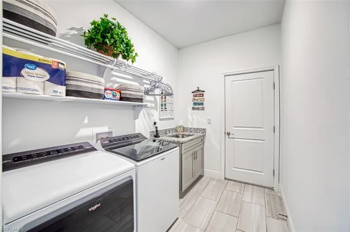 Washroom featuring washer and clothes dryer and cabinet space