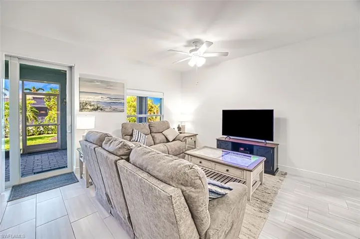 Living room with a ceiling fan and baseboards