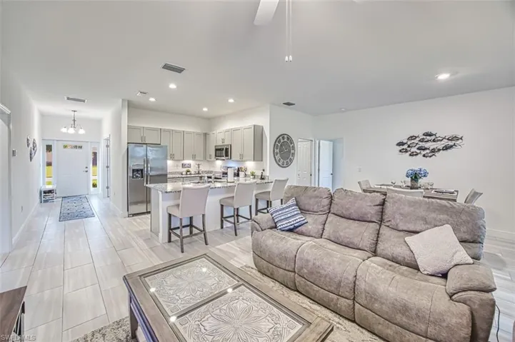 Living area with recessed lighting, a chandelier, and a ceiling fan