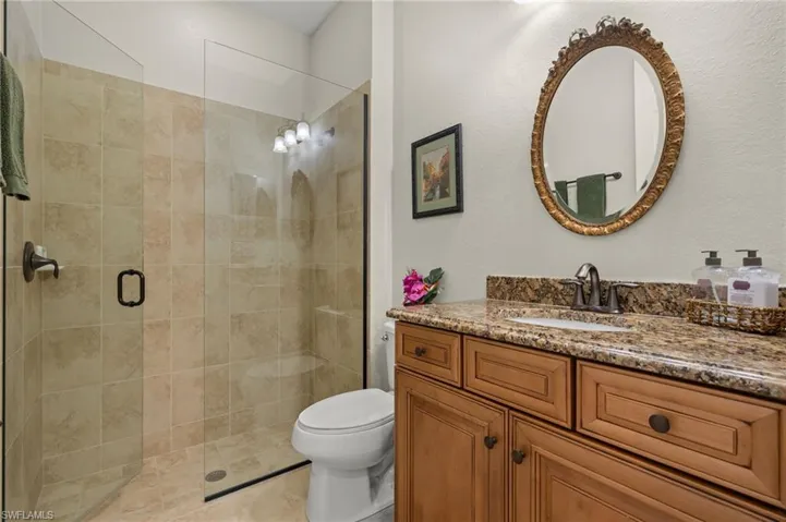 Bathroom featuring vanity, toilet, and a shower with shower door