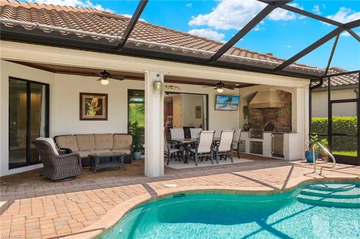 View of pool featuring ceiling fan, an outdoor hangout area, glass enclosure, and a patio area