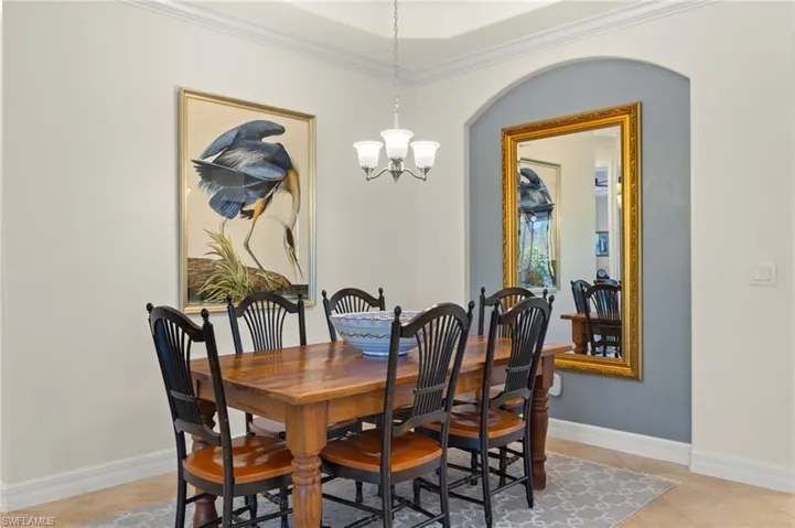 Dining room with an inviting chandelier and crown molding