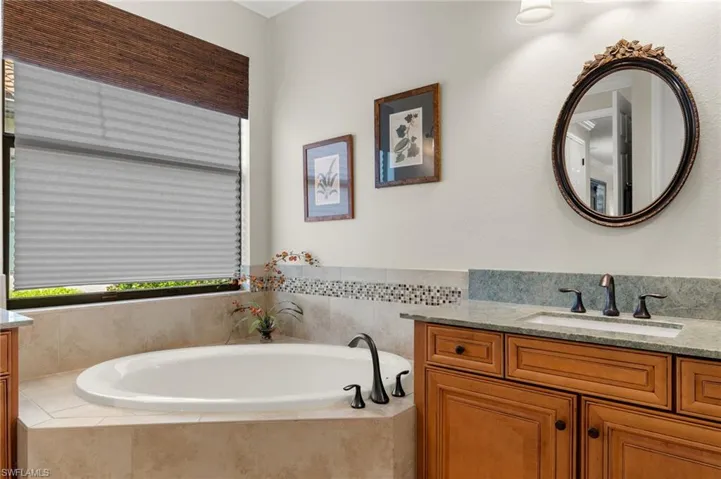 Bathroom featuring vanity and a relaxing tiled tub