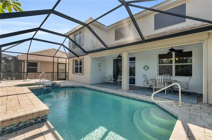View of pool with a patio, glass enclosure, ceiling fan, and an in ground hot tub