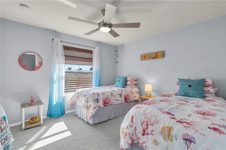Bedroom featuring ceiling fan and carpet