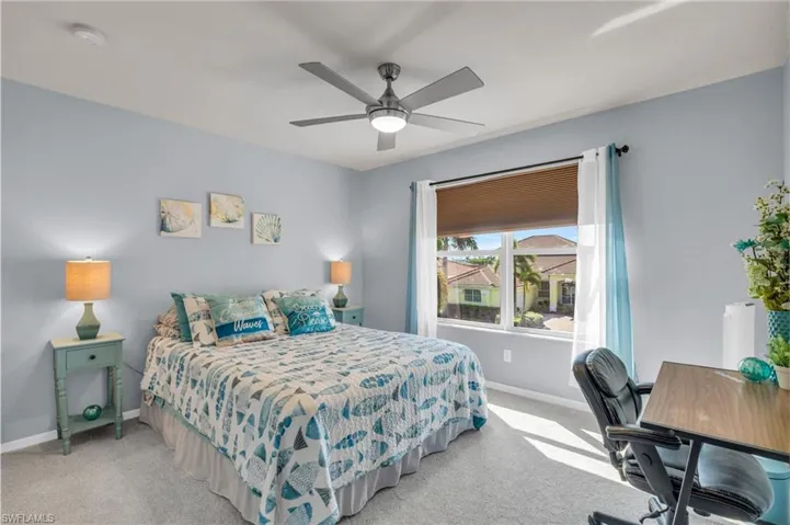 Bedroom with ceiling fan and light colored carpet