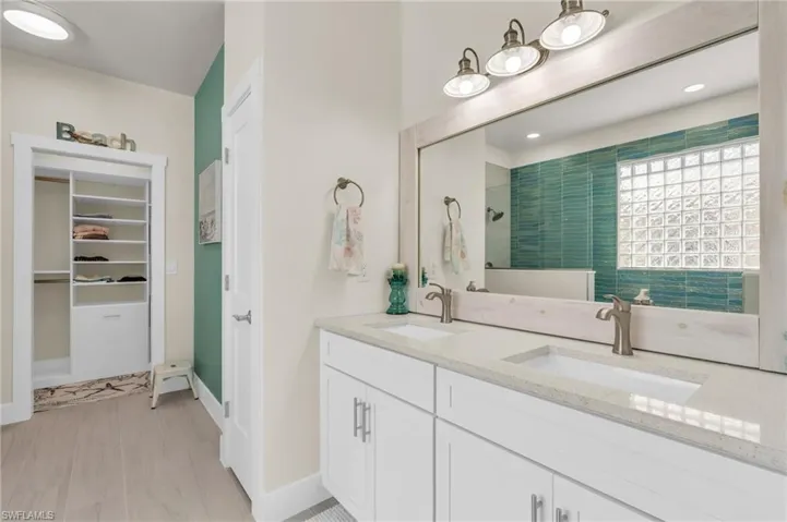 Bathroom with a tile shower, wood-type flooring, and vanity