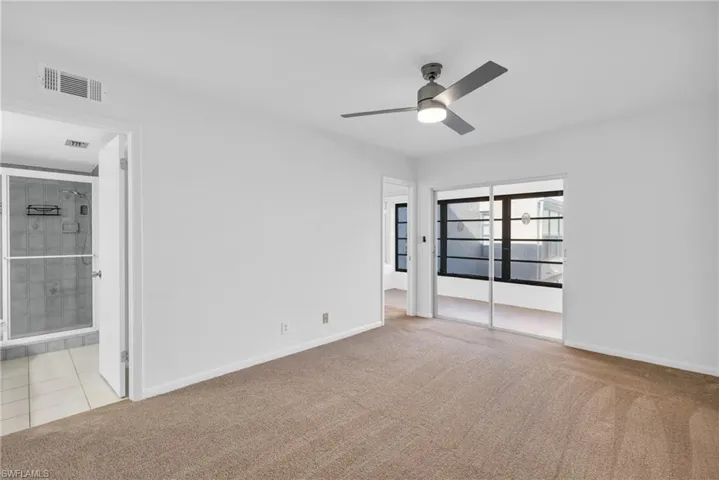 Carpeted empty room featuring ceiling fan