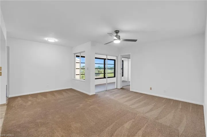 Carpeted living/dining room featuring ceiling fan