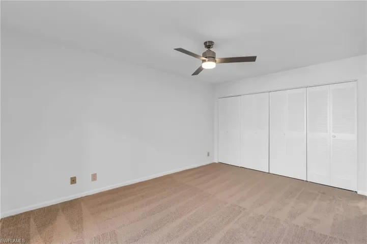 Unfurnished bedroom featuring ceiling fan, a closet, and carpet