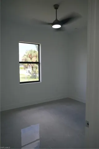 Empty room featuring baseboards and ceiling fan