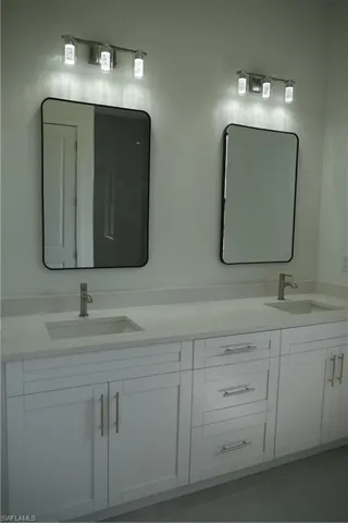 Bathroom with double vanity and tile patterned floors