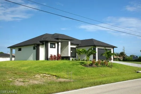 Prairie-style home featuring a garage and a front yard