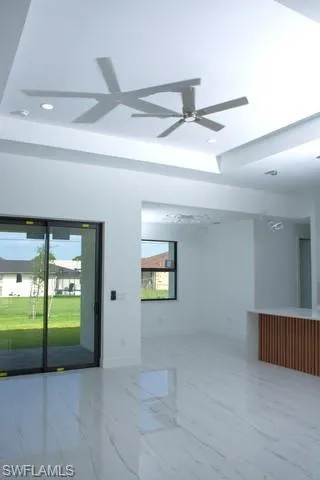 Spare room with ceiling fan and a tray ceiling