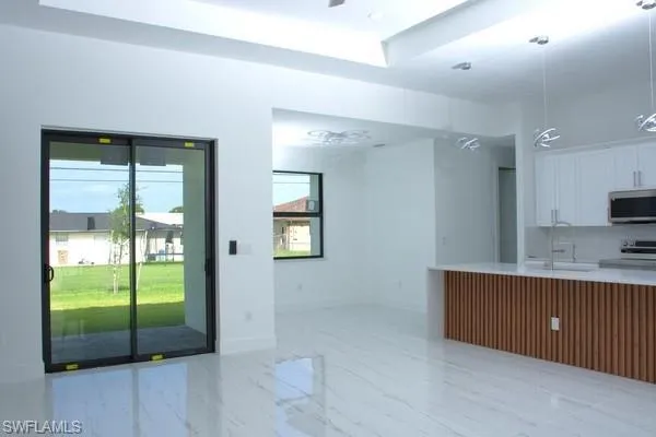 Kitchen featuring white cabinetry, appliances with stainless steel finishes, sink, and a wealth of natural light