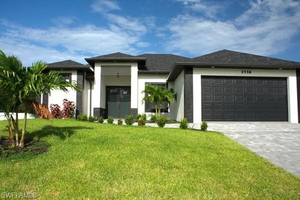 Prairie-style house featuring a garage and a front lawn