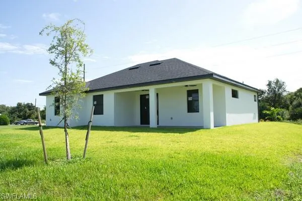 Rear view of property with a yard