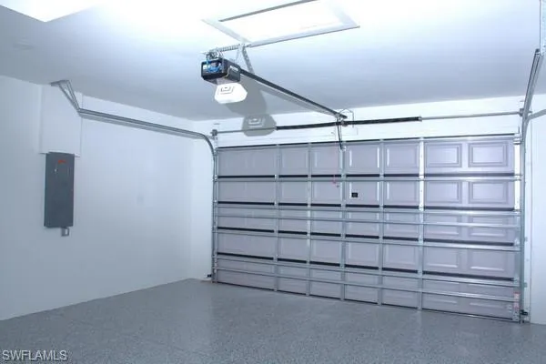 Garage featuring a garage door opener and electric panel