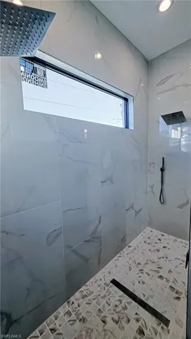 Full bath featuring a marble finish shower