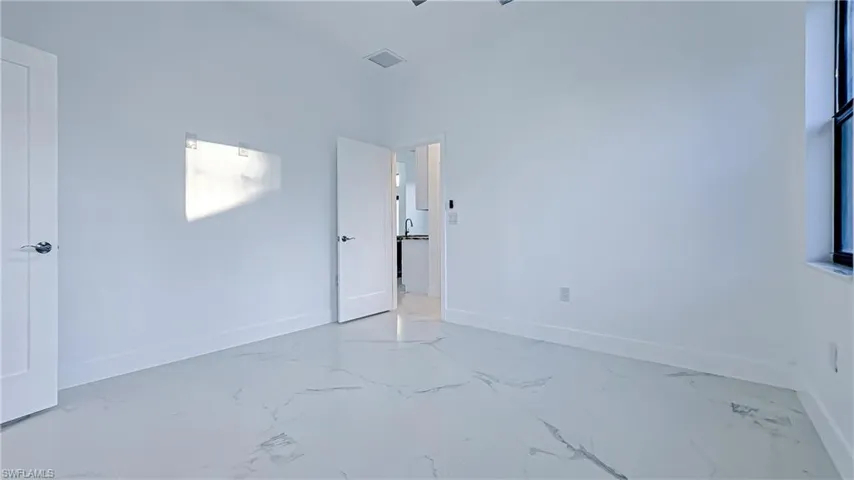 Unfurnished bedroom with baseboards and marble finish flooring