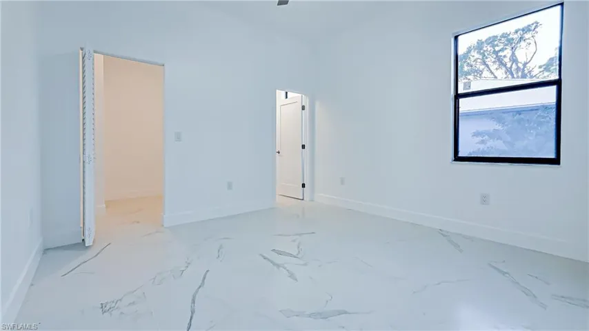 Unfurnished bedroom with a walk in closet and a ceiling fan