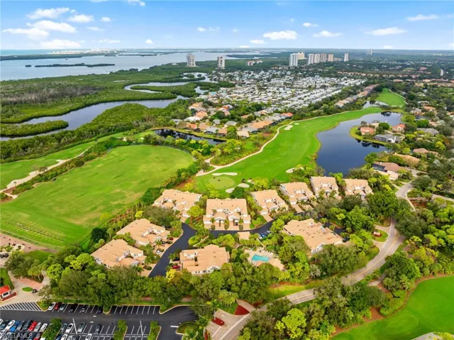 Aerial view of residential area with a local golf course and a nearby body of water