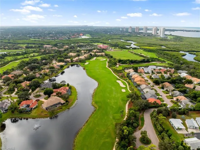 Aerial view of residential area featuring a large body of water and a local golf course