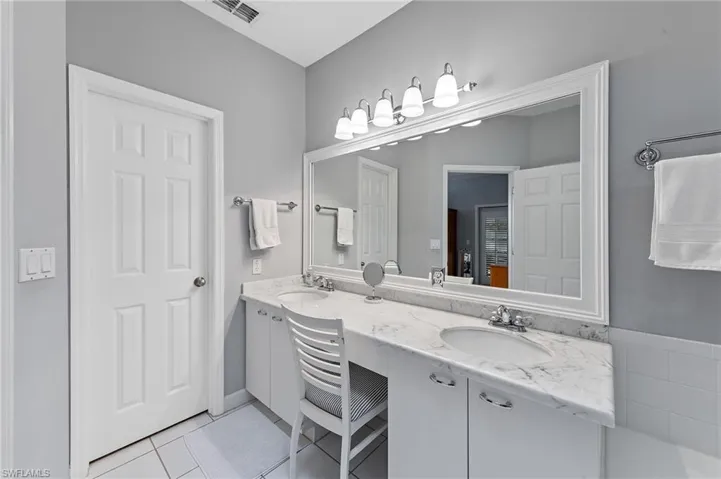 Full bath featuring double vanity and light tile patterned flooring