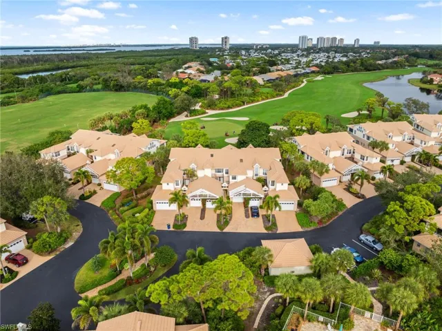 Aerial perspective of suburban area featuring a nearby body of water and a golf club