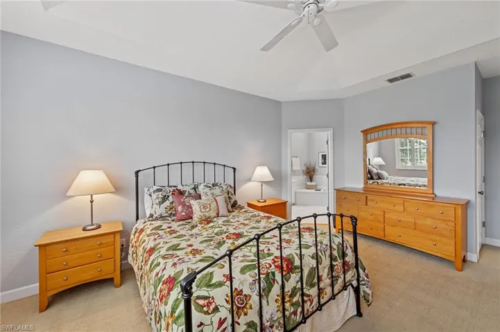 Bedroom featuring light colored carpet, ceiling fan, and connected bathroom