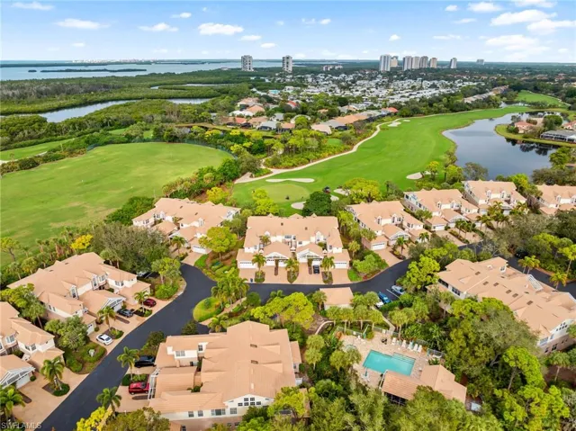 Aerial perspective of suburban area with a nearby body of water and a golf course
