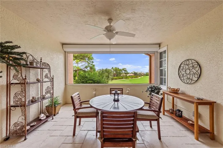 Dining space featuring a textured wall, stone tile flooring, healthy amount of natural light, a ceiling fan, and a textured ceiling