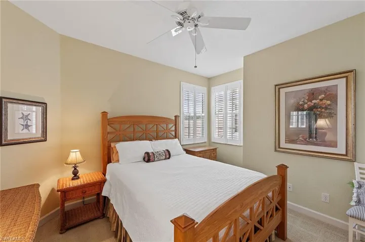 Carpeted bedroom with baseboards and ceiling fan