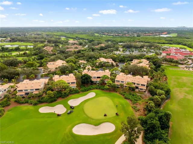 Aerial view of residential area featuring a golf course and a large body of water