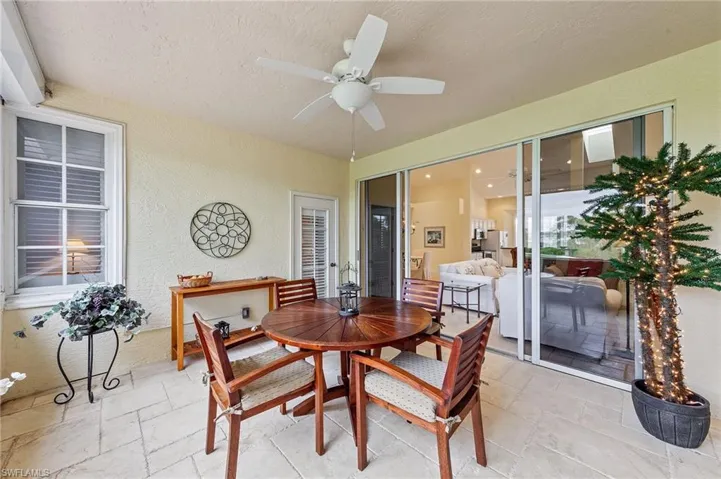 Sunroom / solarium with ceiling fan, outdoor dining area, and a patio area