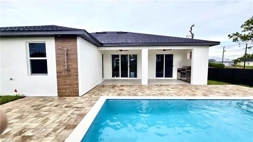 Rear view of house featuring a ceiling fan, a patio area, and stucco siding
