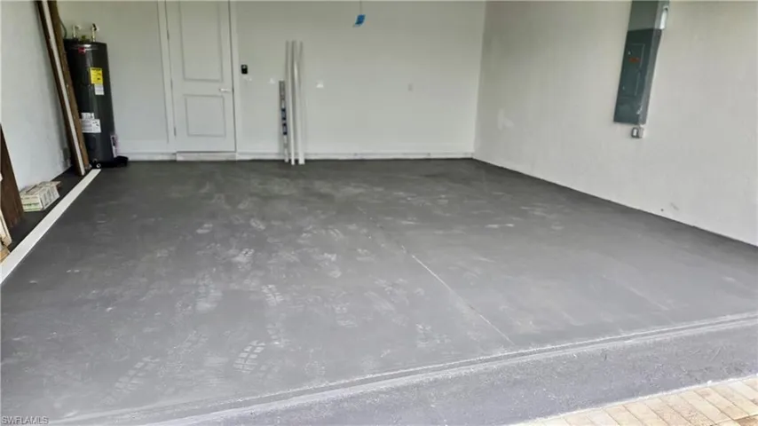 Garage featuring water heater and electric panel