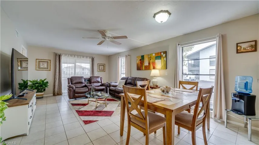 Dining room with light tile patterned floors, ceiling fan, and healthy amount of natural light