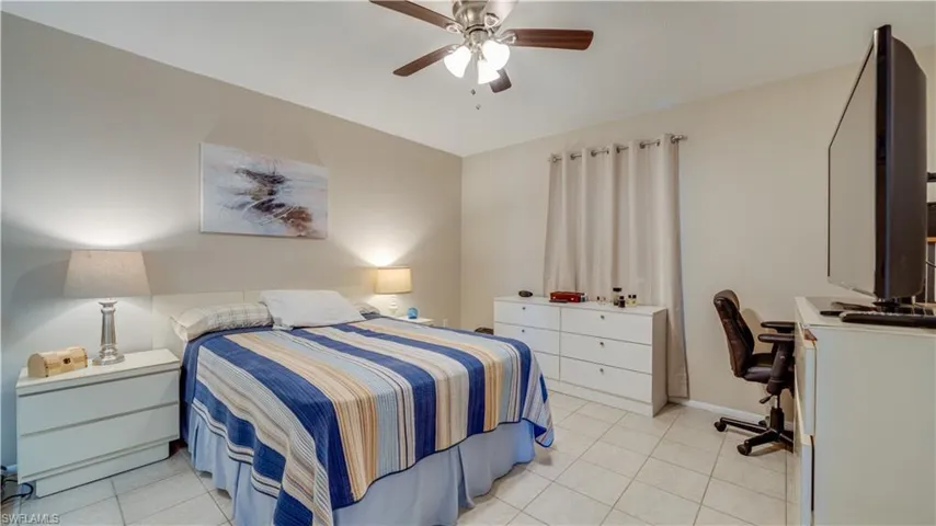 Bedroom featuring a desk, a ceiling fan, and light tile patterned flooring