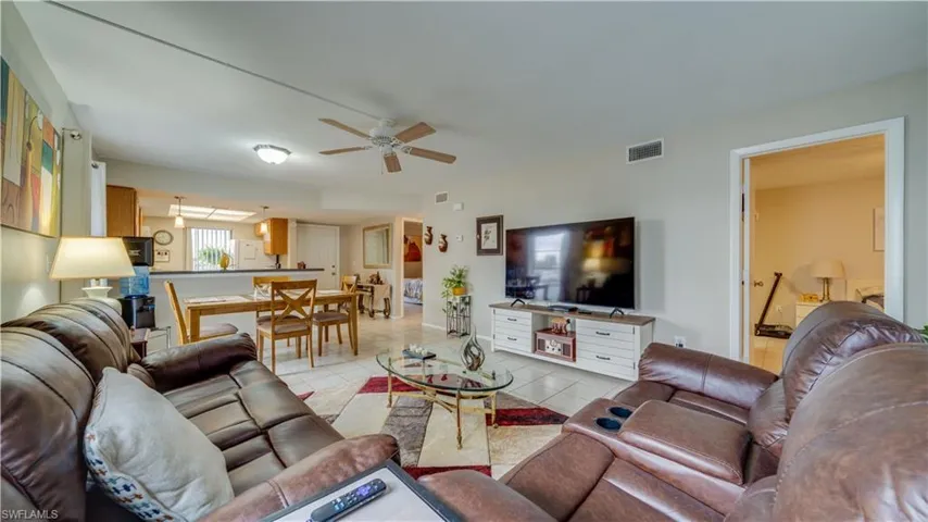 Living area with light tile patterned flooring and a ceiling fan