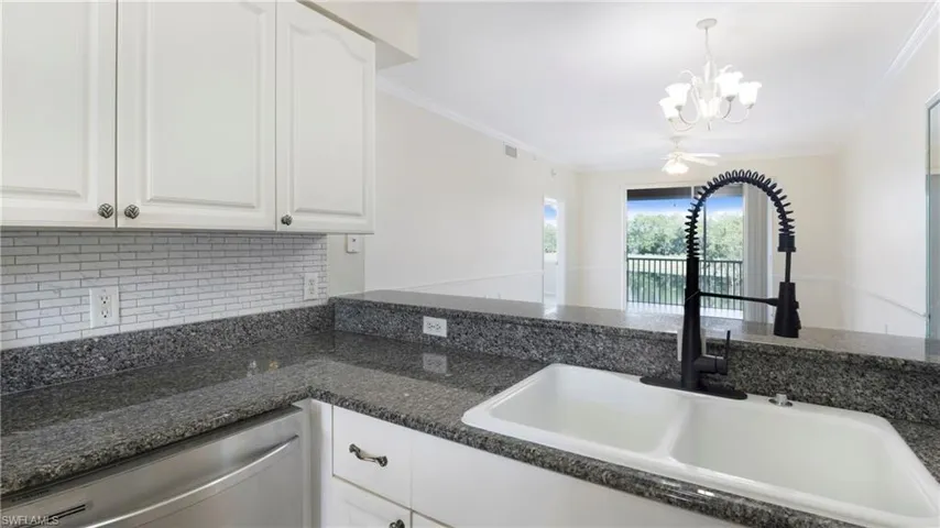 Kitchen featuring white cabinetry, dishwasher, crown molding, decorative backsplash, and pendant lighting