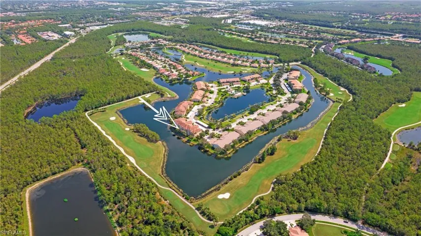 Aerial view of property and surrounding area featuring a nearby body of water and a local golf course