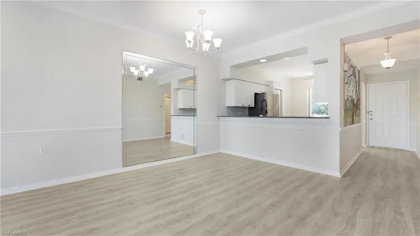 Unfurnished living room featuring light wood-type flooring and crown molding